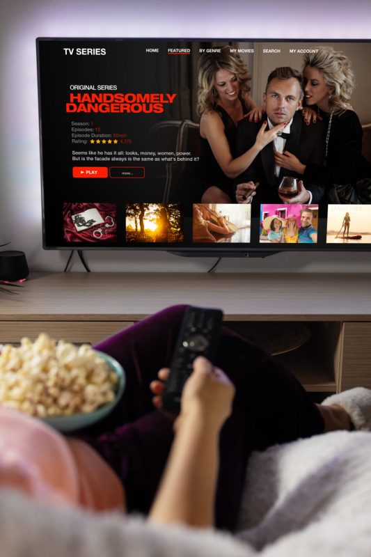 Woman watching TV series and movies via streaming service at home